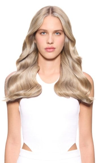 Modelo com o cabelo loiro, ondulado e brilhante.