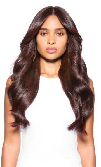 Modelo com cabelo castanho, ondulado, e brilhoso.